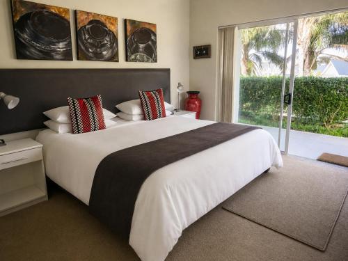 a bedroom with a large white bed and a window at Monte Vidéo Guesthouse in Wellington