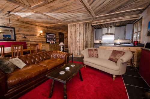 a living room with a couch and a table at Black Diamond Sainte Foy Chalets in Sainte-Foy-Tarentaise