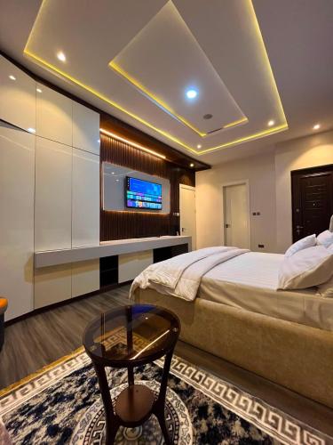 a bedroom with a bed and a tv and a table at Didi's Apartment in Lekki