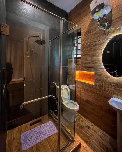 a bathroom with a shower with a toilet and a sink at Didi's Apartment in Lekki
