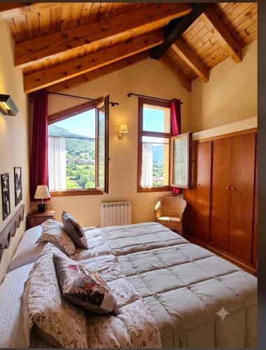 a bedroom with a large bed and a large window at San Marsial Benasque Apart Hotel in Benasque