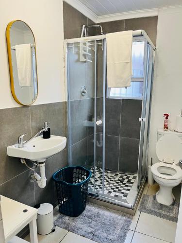 a bathroom with a shower and a toilet and a sink at Covenant Place in Cape Town