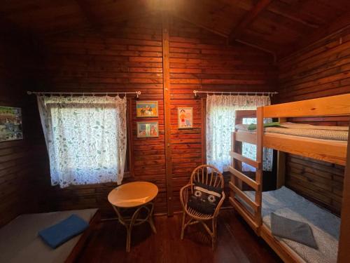 a room with a bunk bed and a table and chairs at Ośrodek Wypoczynkowy Sielawa in Chrzypsko Wielkie