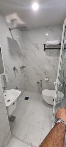a white bathroom with a sink and a toilet at فندق برج الحوراء ع in Karbala