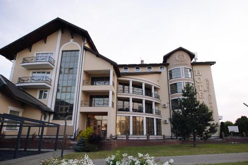 a large white building with windows at Warszawa Hotel in Lviv