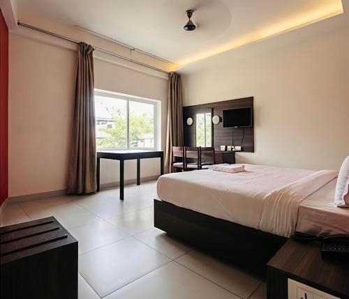 a hotel room with a bed and a desk at Hotel Golden Heights International in Ernakulam