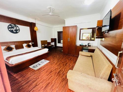 a hotel room with a bed and a couch at The Ashoka Tiger in Dhikala Zone