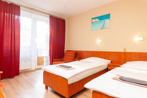 a hotel room with two beds and a window at Penzión ORION in Prievidza
