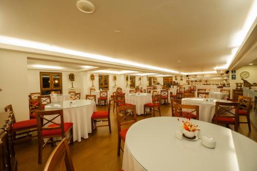 a dining room with white tables and chairs at San Agustin Plaza in Cusco