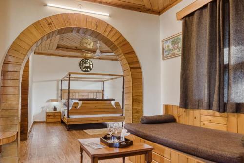 a living room with a bed and an archway at The Ashoka Tiger in Dhikala Zone