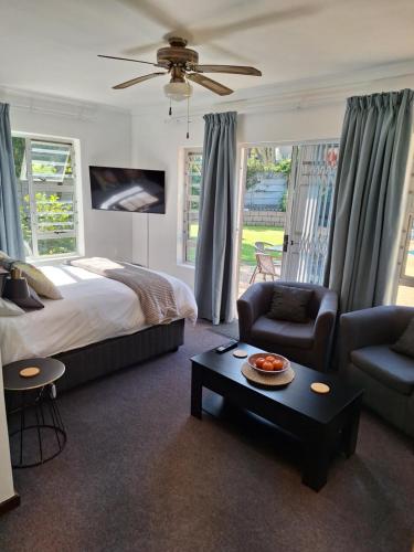 a bedroom with a bed and a couch and a table at Dee-One's at Napier in Kenridge