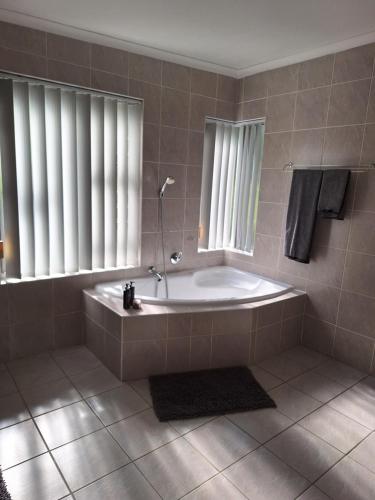 a bathroom with a tub and two windows at Dee-One's at Napier in Kenridge