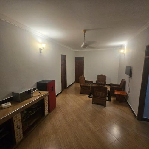 a living room with a table and chairs and a tv at Paradiso Apartments in Dar es Salaam