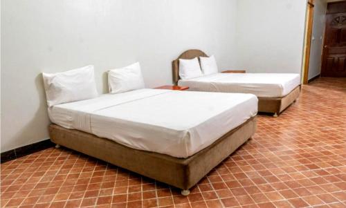 two beds sitting in a room with at Paradiso Apartments in Dar es Salaam