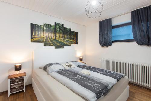 a bedroom with a bed and two paintings on the wall at Schwarzwaldglück in St. Blasien