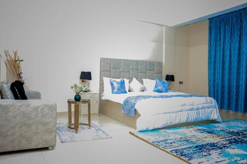 a bedroom with a large bed with blue curtains at mudha hotel in Hargeysa