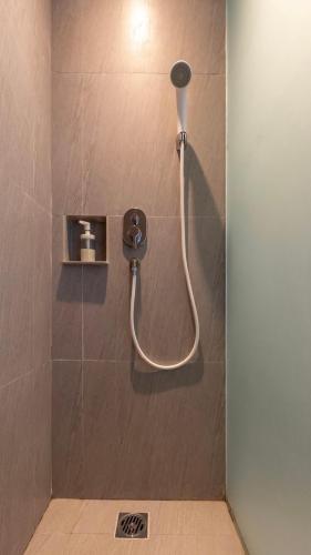 a shower with a hose in a bathroom at Shashvata Berawa in Badung