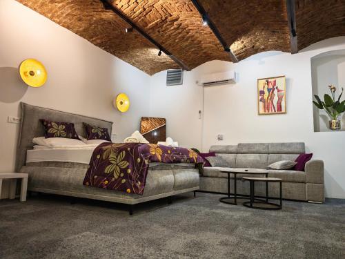 a bedroom with a bed and a couch and a table at Apartments Guinness in Sarajevo