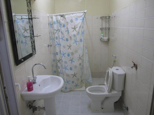 a bathroom with a toilet and a sink at العين الهيلي مصباح بيت 2 in Al Ain