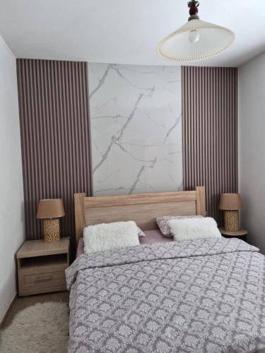 a bedroom with a bed and a large marble wall at Apartmani “Dunja” in Kraljevići