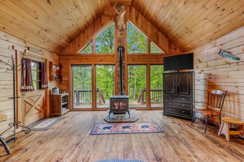 a living room with a fireplace in a log cabin at Seventh Heaven - Hot Tub, Pet Friendly, Grill, Wifi, Deck, Covered Porch, Family Friendly, Kid's Loft, King Bed in Great Cacapon