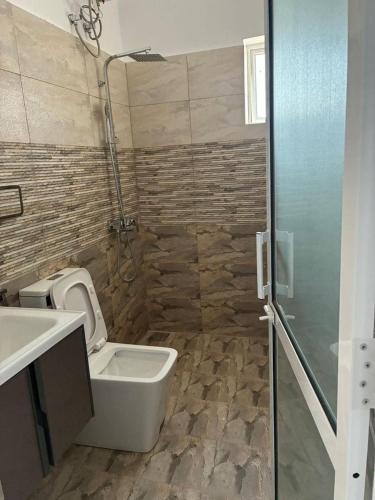 a bathroom with a toilet and a sink and a shower at Bay Nest in Wellawatta