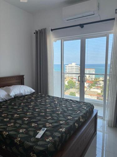 a bedroom with a bed with a view of the ocean at Bay Nest in Wellawatta