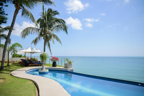 a swimming pool with the ocean in the background at Hotel Vistalmar in Manta