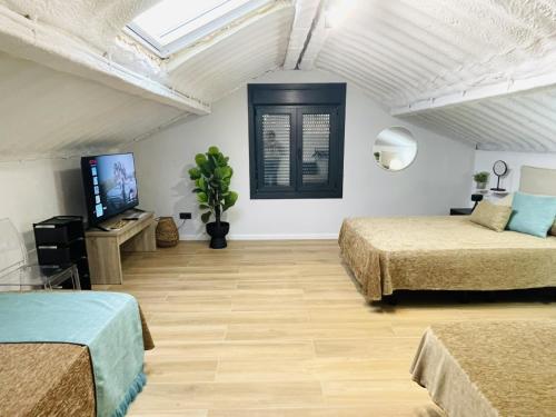 a room with two beds and a flat screen tv at Villa 1-12 Personas a 3 minutos de las playas in Villanueva de Arosa