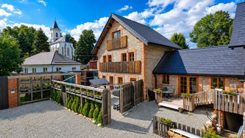 a brick building with a wooden fence and a church at Liptov Lodge in Liptovský Mikuláš