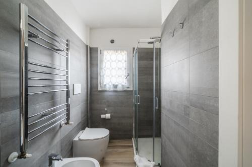 a bathroom with a toilet and a glass shower at Villa Viani in Soliera