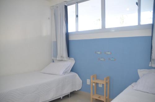 a bedroom with two beds and a window at #204 Corais de Búzios - Apartamento à beira-mar na enseada de Búzios in Nísia Floresta