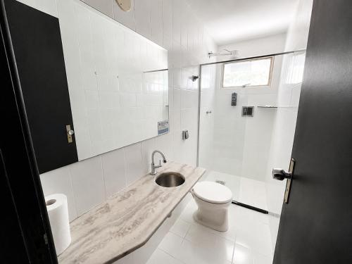 a white bathroom with a sink and a toilet at Hotel Montana Aeroporto by Bsb Inn in Brasília