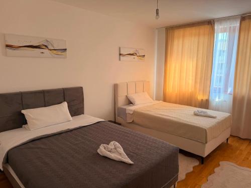 a bedroom with two beds and a pair of shoes on the bed at Elite Suites - Vogošća in Vogošća