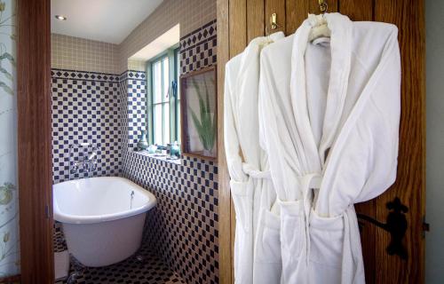a bathroom with a bath tub and a sink at Palé Hall Hotel & Spa in Bala