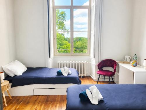 a bedroom with two beds and a window at Château de Savonnières in La Bruère-sur-Loir