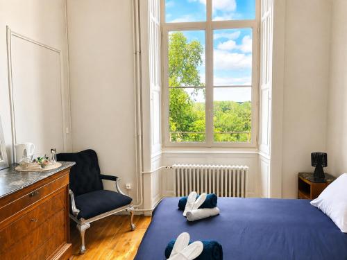 a bedroom with a bed and a chair and a window at Château de Savonnières in La Bruère-sur-Loir