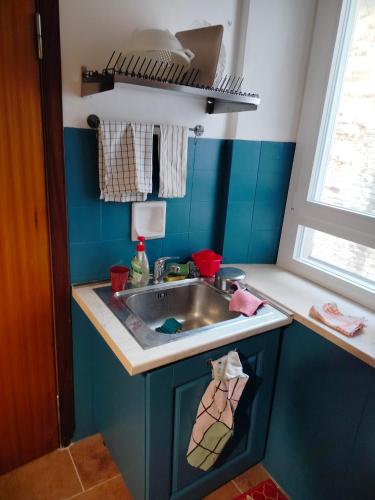 a small kitchen with a sink and blue walls at Casa del Sole 2 artenatura in Pergola