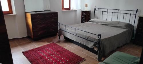 a bedroom with a bed and a dresser and a red rug at Casa del Sole 2 artenatura in Pergola