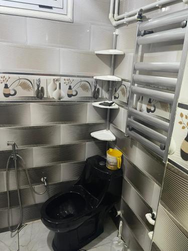 a bathroom with a black toilet in a room at Chimino in Sétif
