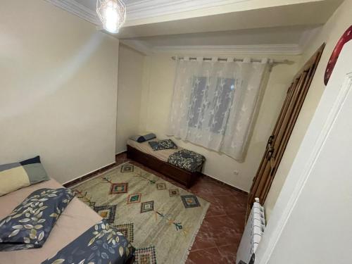 a small room with two beds and a window at Chimino in Sétif