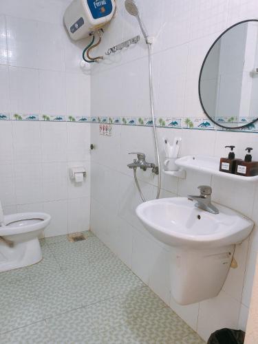 a bathroom with a sink and a toilet at Full House Cát Bà in Cat Ba