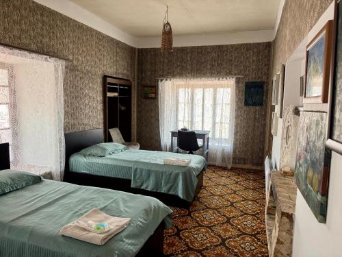 a hotel room with two beds and a desk at Khachats Toun Heritage in Meghri