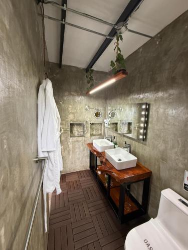 a bathroom with two sinks and a toilet at Oasis Glamping Tena Cun Vía La Mesa Anapoima in Tena