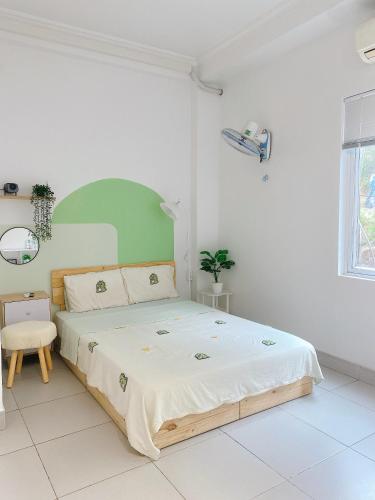 a bedroom with a large bed in a white room at Full House Cát Bà in Cat Ba