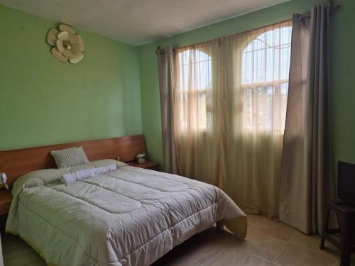 a bedroom with a bed and a large window at Casa de los Sauces in Toluca