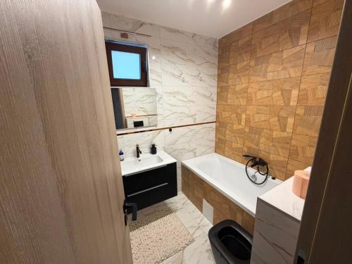 a bathroom with a sink and a tub and a toilet at Mély-Patak Vendégház in Erdőbénye