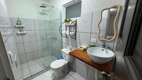 a bathroom with a sink and a toilet and a shower at Basecamp Monteverde in Monteverde Costa Rica