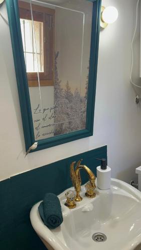 a bathroom with a sink with a mirror and a sink at La Alcoba de los Cuentos in Urueña