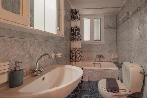 a bathroom with a tub and a toilet and a sink at Villa Agrielia in Póndi